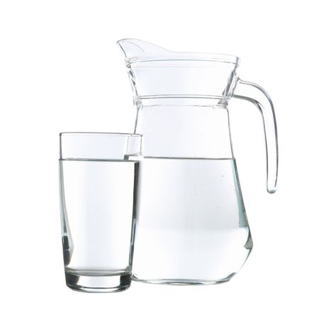 Pitcher of water and glass in plain room