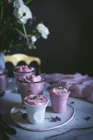 tasty glasses of strawberry mousse on a table with flowers