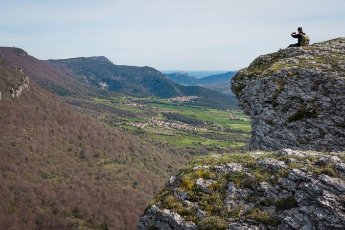 Tourist sitting on high mountain