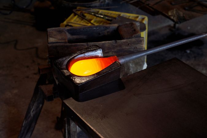 Blowpipe with melted glass in workshop