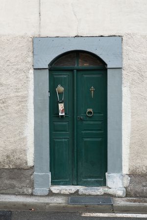 Building with green door and flowers on steps