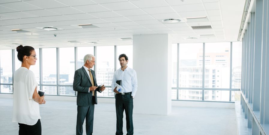 Real estate agent talking with clients inside an empty office space