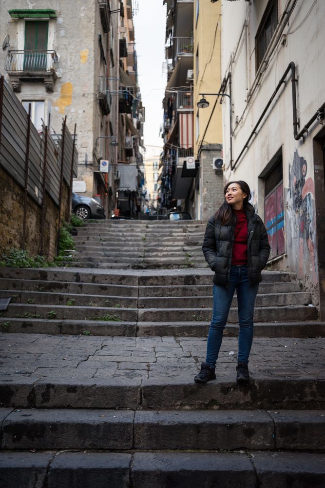 woman standing on steps on shabby street