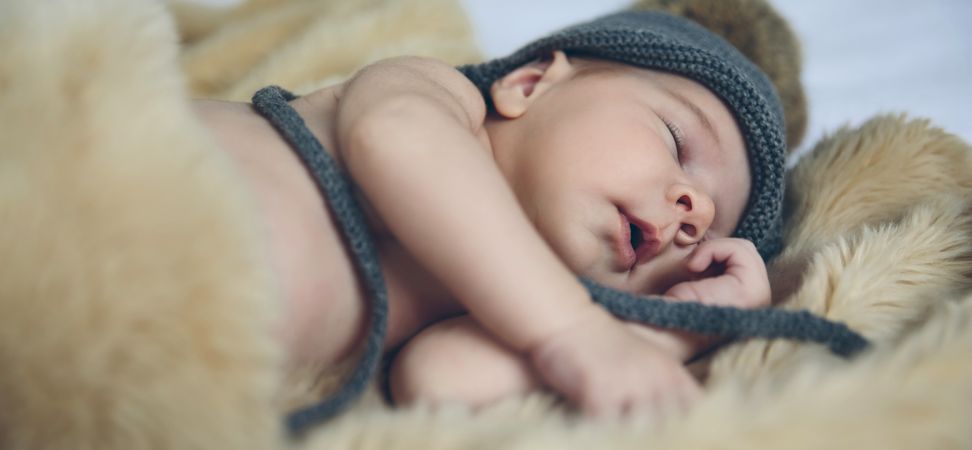 Baby girl with pompom hat sleeping