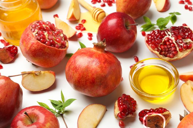 Close up of pomegranate with apples, honey and mint leaves