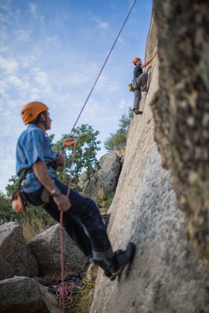 Climbers in safety harness climbing mountain