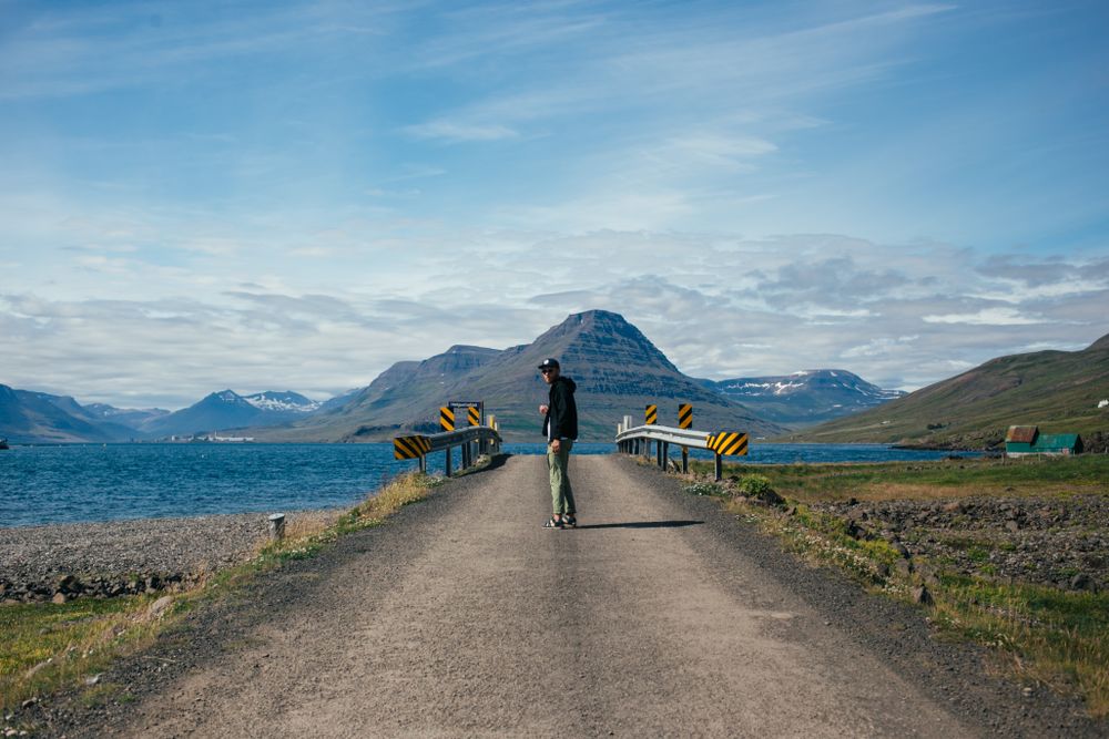 Man walking towards rural bridge