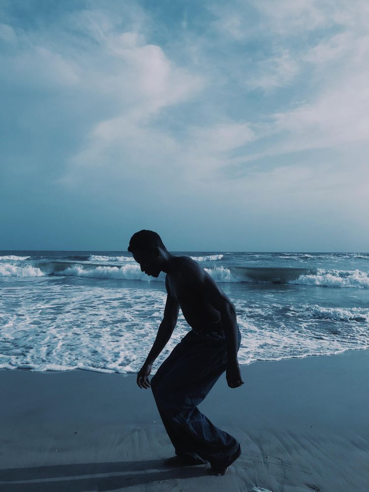 Side view silhouette of young man standing on the beach