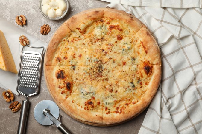 Cheese pizza and ingredients for cooking on gray background
