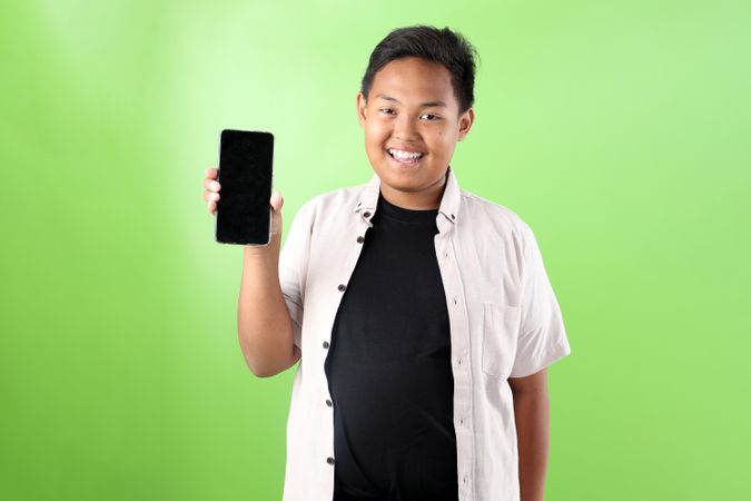 Young Indonesian Boy Holding Blank Screen of Mobile Cell Phone