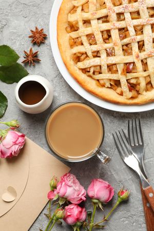 Composition with apple pie and ingredients on gray background, top view