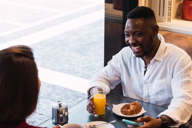 Multiracial couple having breakfast in cozy cafe