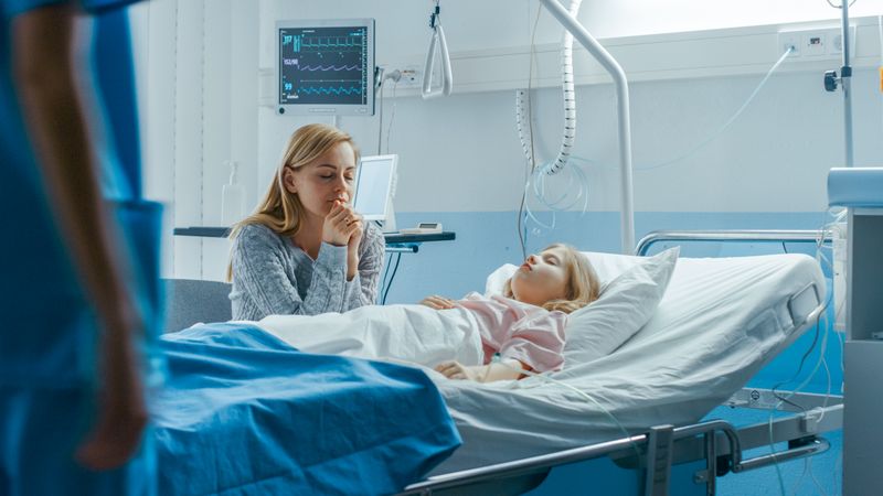 Sick Little Girl Lying in the Hospital Bed Sleeping, Her Mother Worries  and Prays Beside Her.