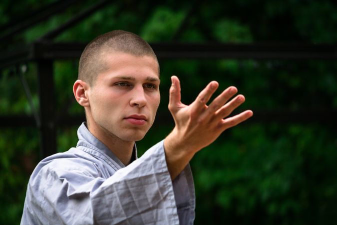Bald woman practicing martial arts in garden