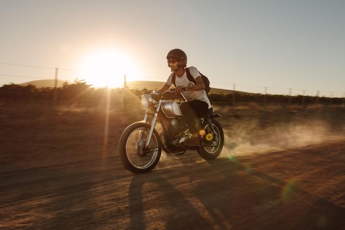 Young man riding a vintage motorcycle off-road