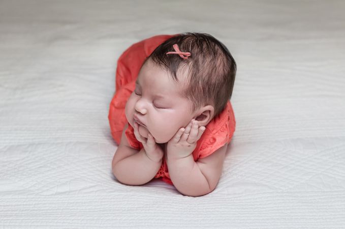 Beautiful newborn baby sleeping on her elbows and hands