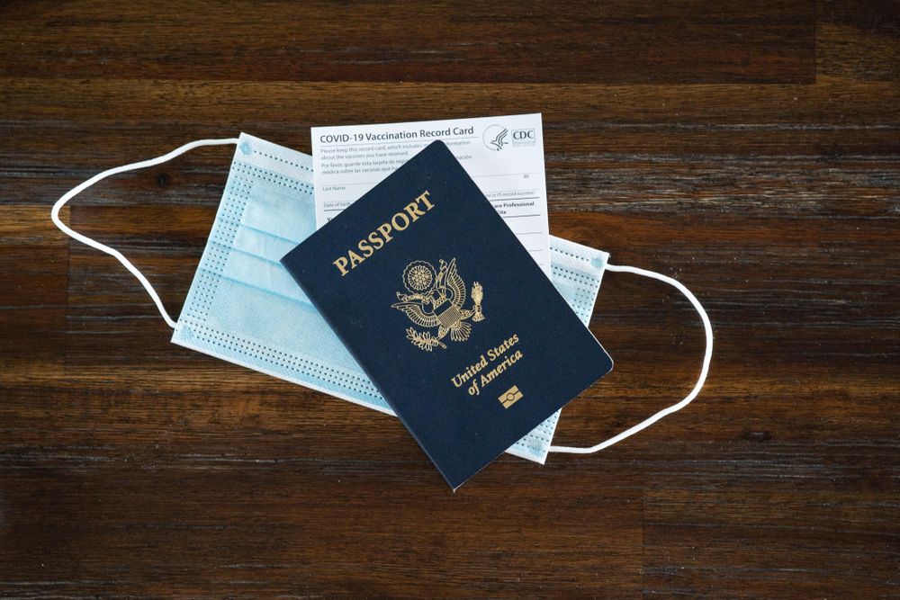 Top view of PPE mask, COVID vaccine card and US passport