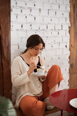 Peaceful woman drinking coffee while resting at home