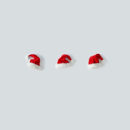 Santa hats in a row on light background