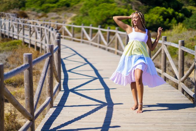 Female walking on a pedestrian walkway in colorful dress with space for copy