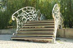 Little bridge in city park in bright sunny morning