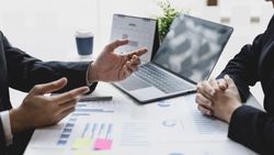Business People Looking at Graphs in Meeting