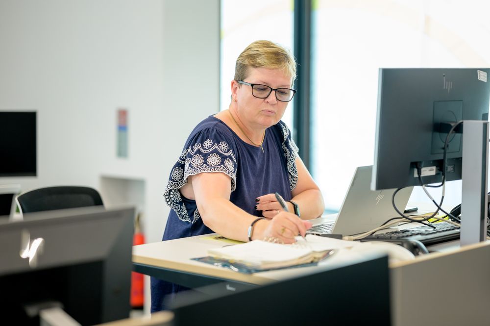 Older woman sitting in office taking notes