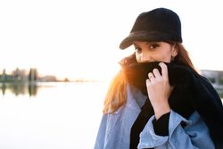 Charming woman in casual wear on shore of lake