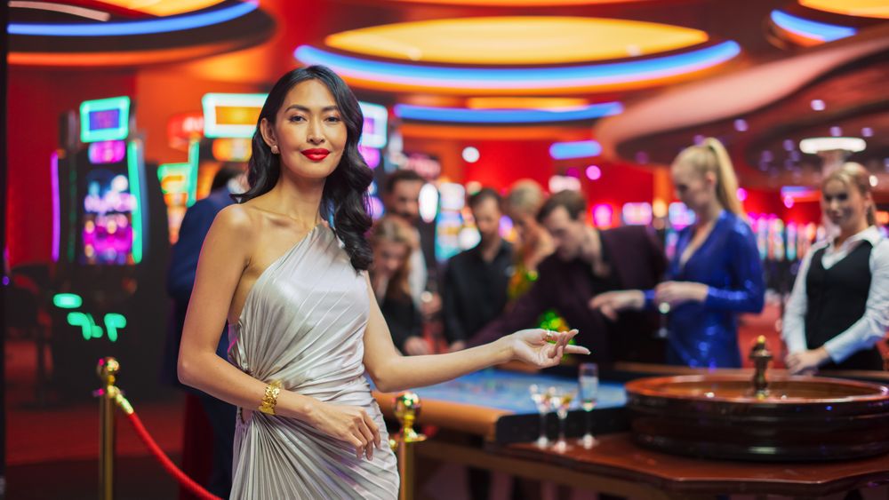 Young Asian Woman, Wearing an Elegant Silver Dress, Standing in a Modeling Pose in a Glamorous Atmosphere