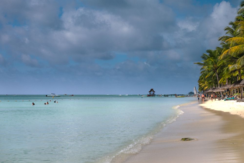 Idyllic water on busy Mauritius beach on cloudy day