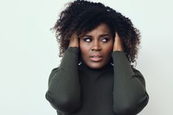 Annoyed Black woman with her hands in her hair