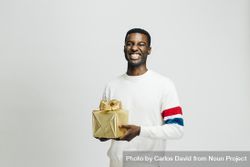 Happy Black man holding gold box in his hands 4mx2v5