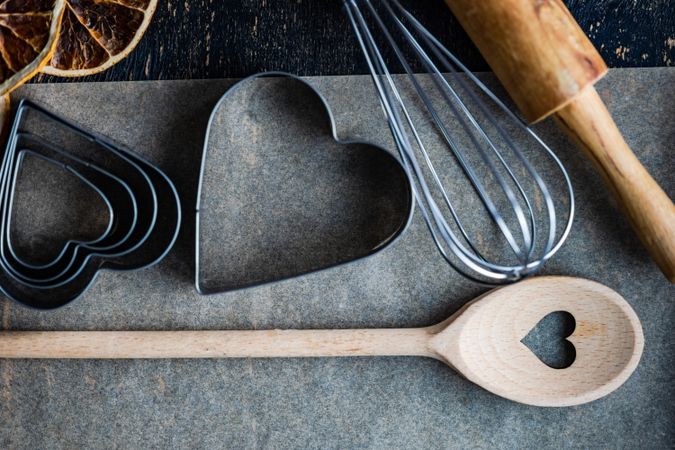 Top view of heart shaped cookie cutters and baking equipment in kitchen