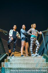 Group of female runners team standing on stairs at night ready for an evening exercise session 432QBV