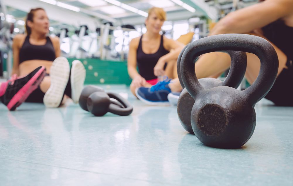 Kettle bells on ground among group of fit people