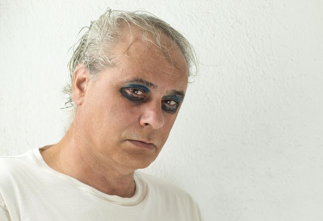 Portrait of sad middle aged man with eyeshadow