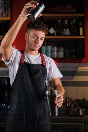 Focused man mixing drink in bar