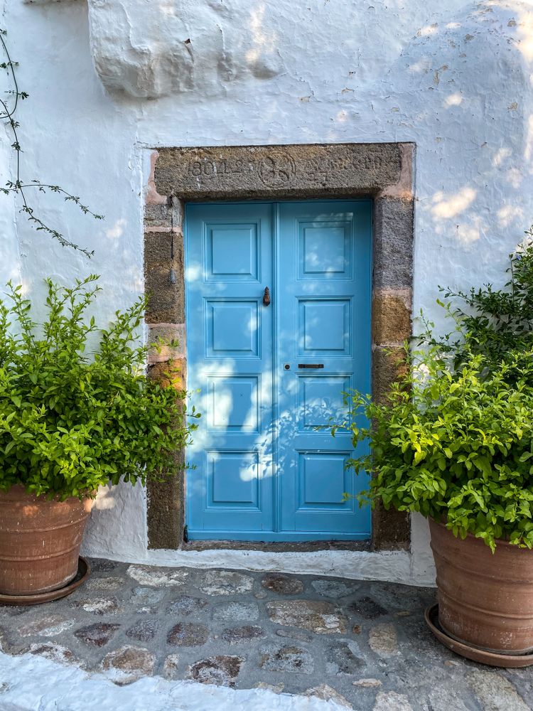 Patmian blue door with potted plants
