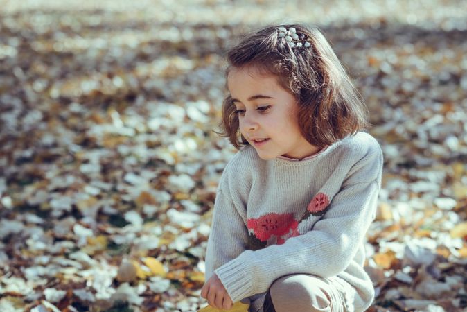 Happy child in field of colorful fall leaves