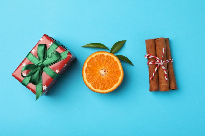 Mandarin, cinnamon and gift box on blue background
