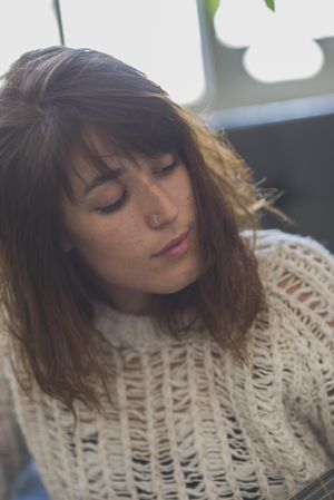 Close up of woman looking at fretboard of guitar