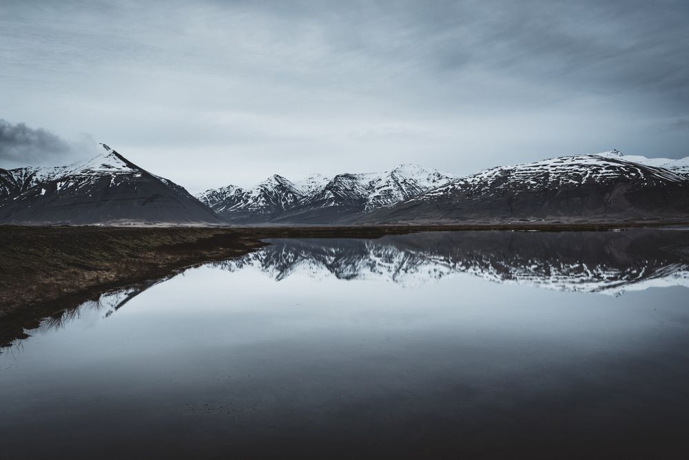 Snowcapped mountains reflected In still lake