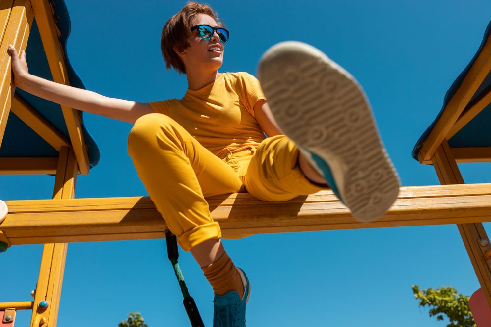 Cool stylish young woman in vibrant clothes on playground