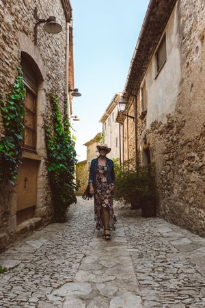 Woman walking in a narrow path in a village
