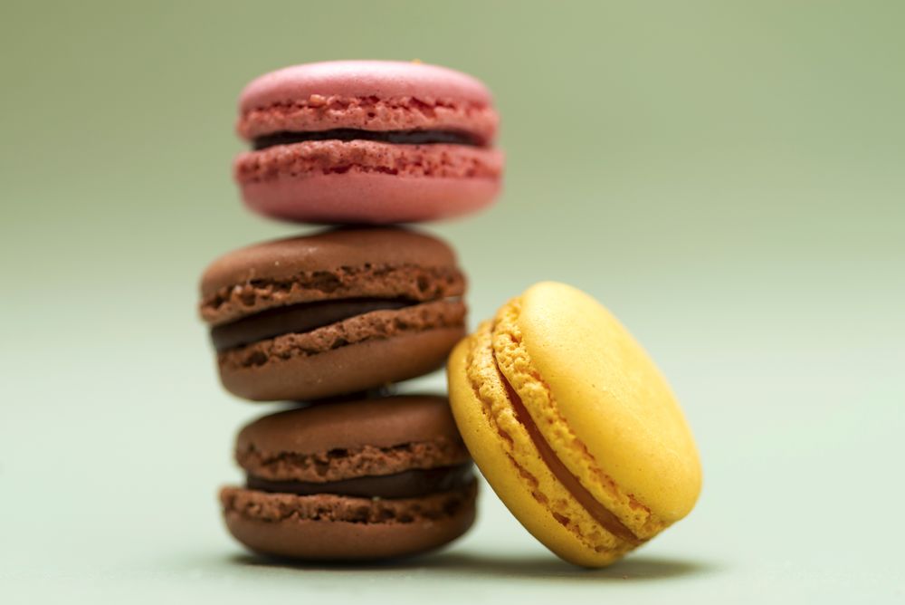 Chocolate, strawberry & lemon macaroons on a green table