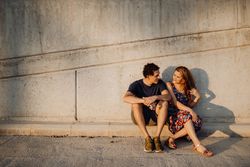 man and woman sitting at nearby street wall