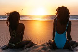 Content Black woman on tropical beach at sunset