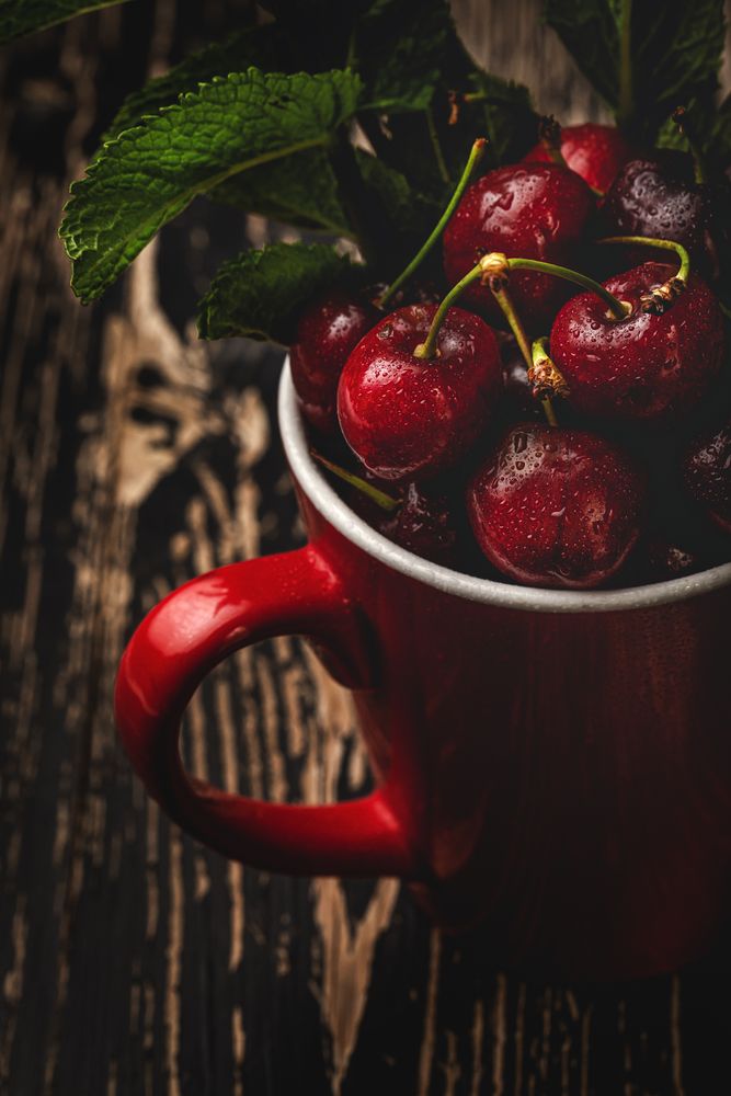 Cherry with branches in cup on table