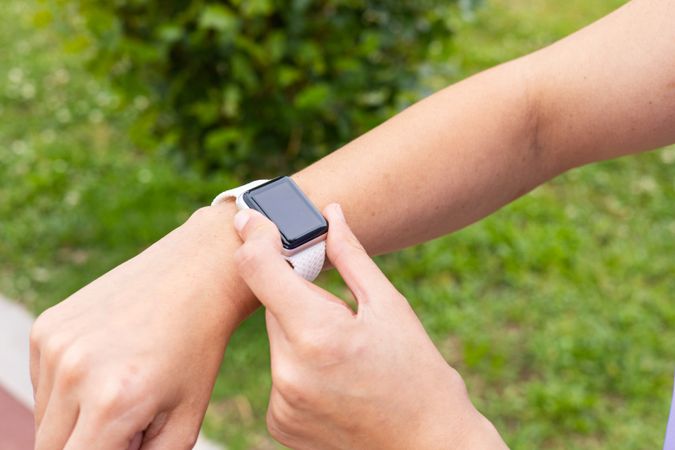 Woman checking a sport smartwatch for running workout outdoors