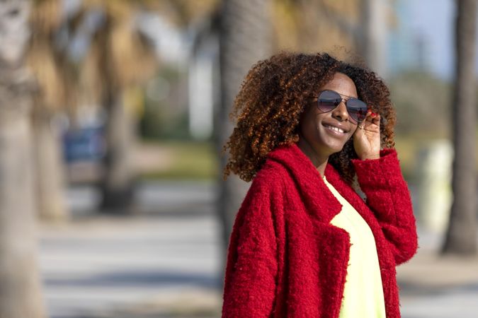 Female smiling in the sun on street with palm trees